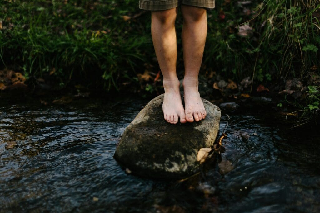 close up child's feet on a big stone